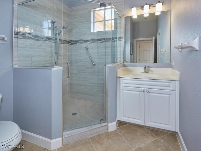 bathroom featuring toilet, vanity, tile patterned floors, and walk in shower