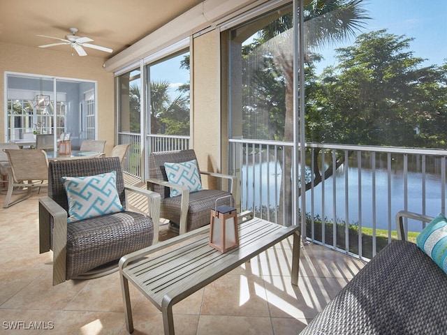 sunroom / solarium featuring ceiling fan and a water view