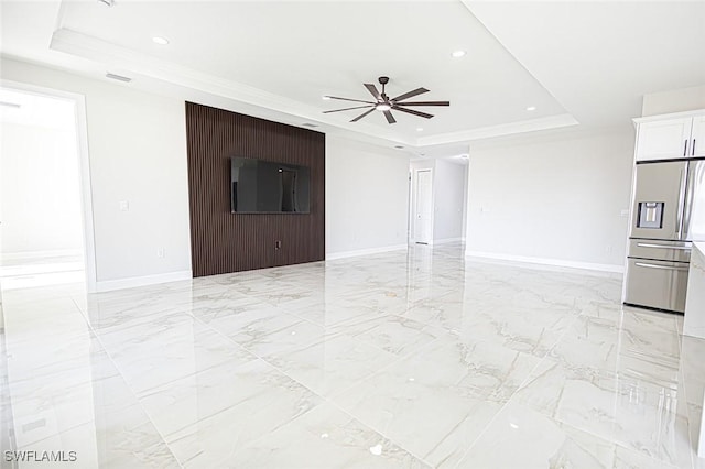 unfurnished living room featuring a raised ceiling, ceiling fan, and ornamental molding