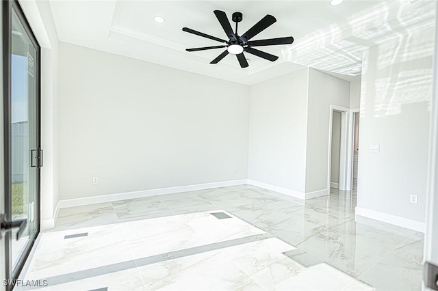 spare room featuring a raised ceiling, ceiling fan, and crown molding