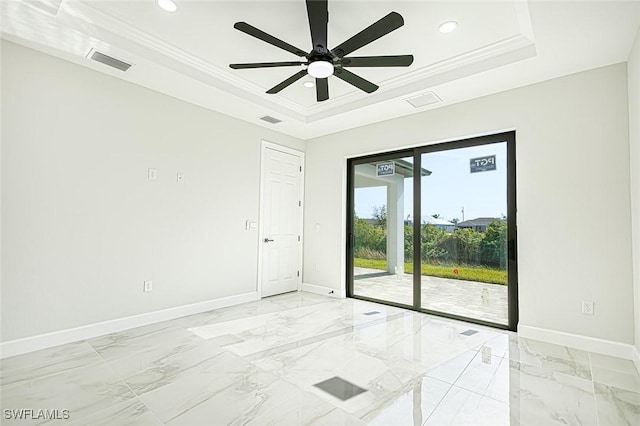 spare room with ceiling fan, ornamental molding, and a tray ceiling