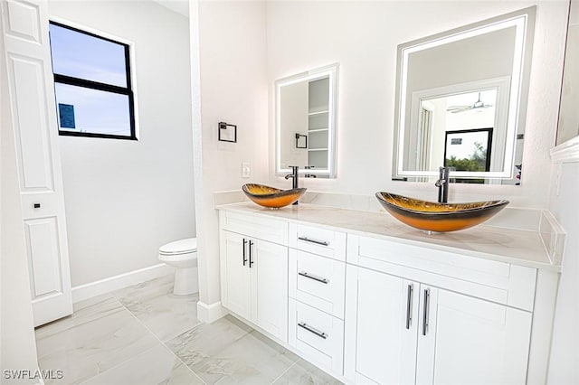 bathroom with vanity, ceiling fan, and toilet