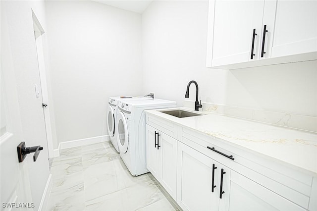 laundry area featuring separate washer and dryer, sink, and cabinets