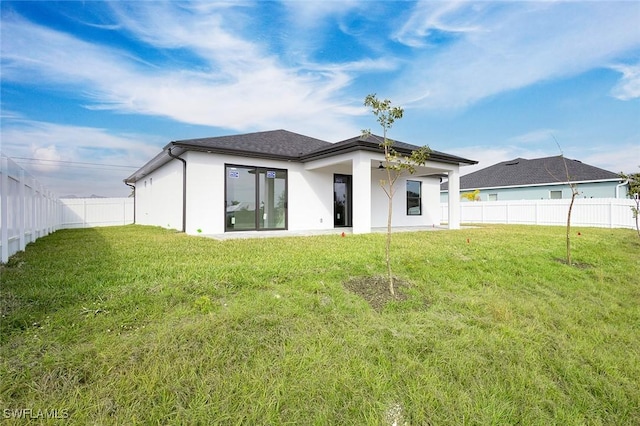 rear view of property featuring a lawn