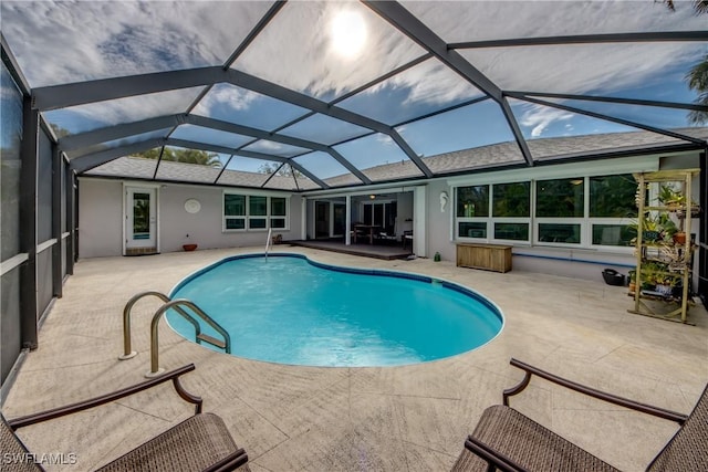 view of pool with glass enclosure and a patio area