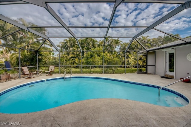 view of swimming pool with glass enclosure and a patio area