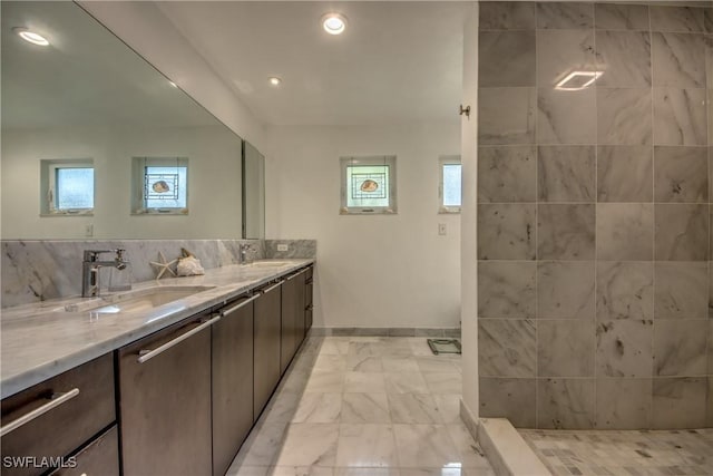 bathroom with vanity, a wealth of natural light, backsplash, and walk in shower