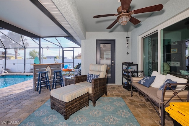 view of patio / terrace featuring glass enclosure, an outdoor hangout area, and exterior bar