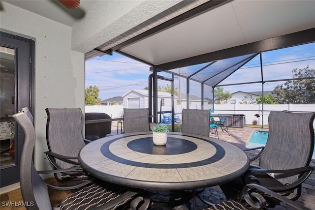 view of patio / terrace with a lanai, a storage shed, and a swimming pool