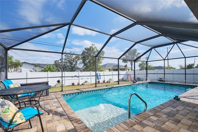 view of pool with glass enclosure and a patio area