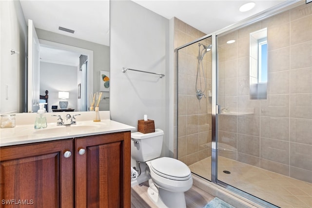 bathroom featuring vanity, hardwood / wood-style flooring, a shower with door, and toilet