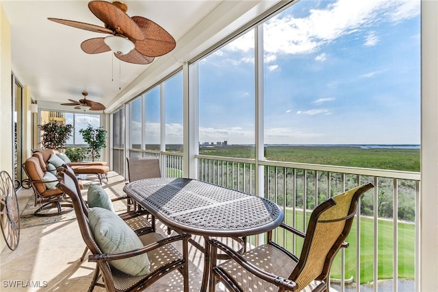 sunroom featuring ceiling fan and plenty of natural light