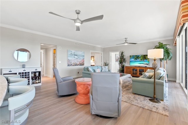 living room featuring ornamental molding, light hardwood / wood-style floors, and ceiling fan