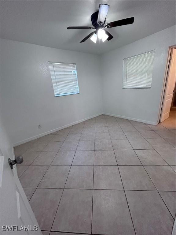 tiled spare room with ceiling fan