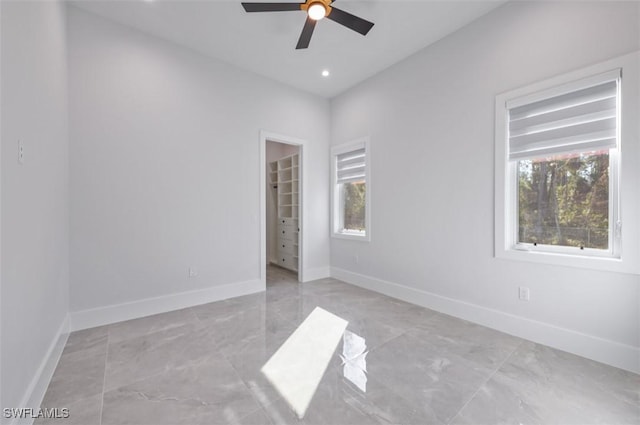 spare room featuring ceiling fan and plenty of natural light