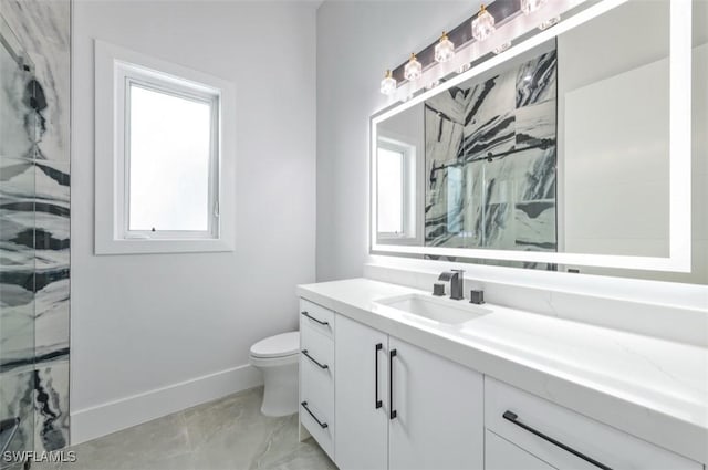 bathroom featuring tiled shower, vanity, and toilet