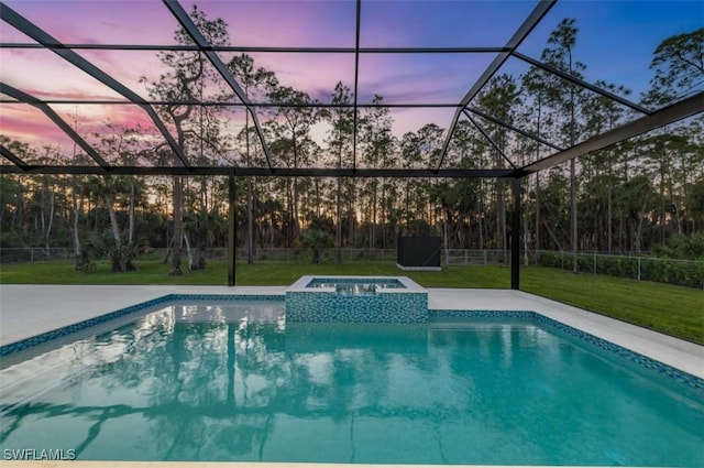 pool at dusk with an in ground hot tub, glass enclosure, and a patio area