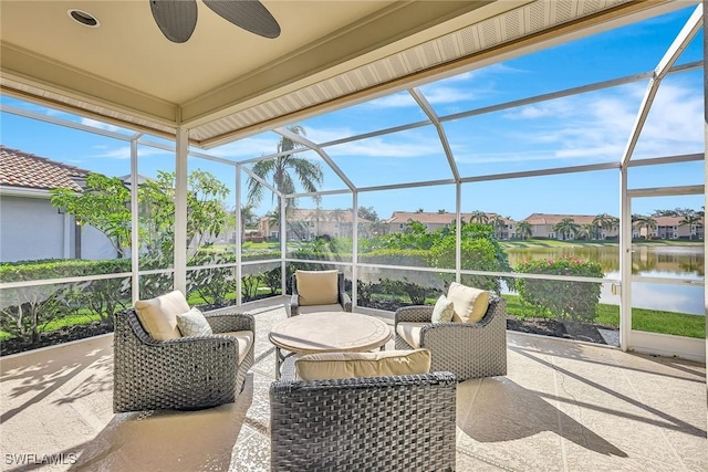 sunroom / solarium featuring ceiling fan and a water view