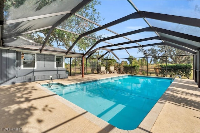 view of pool with glass enclosure and a patio area