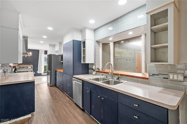 kitchen featuring white cabinets, stainless steel appliances, blue cabinetry, and sink