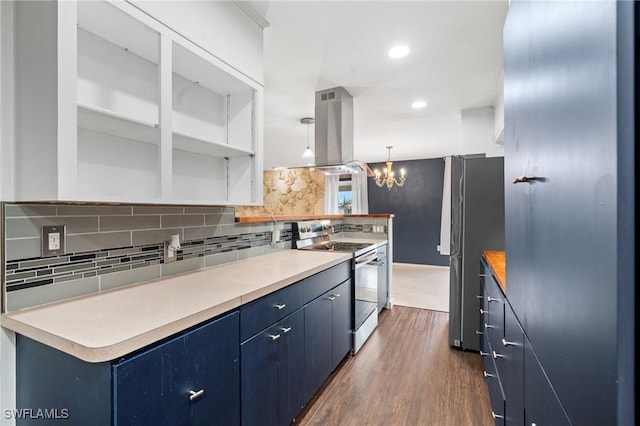 kitchen with dark wood-type flooring, hanging light fixtures, blue cabinetry, island exhaust hood, and stainless steel appliances