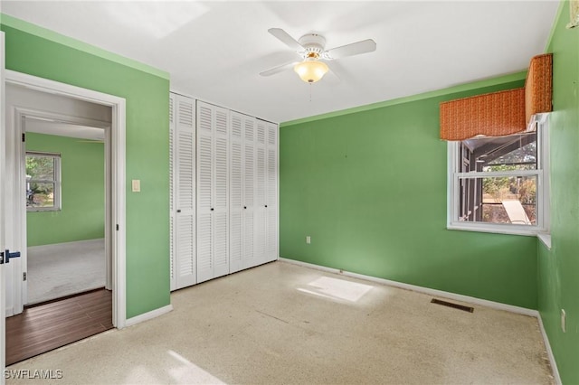 unfurnished bedroom featuring ceiling fan and a closet