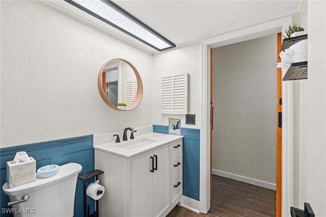 bathroom featuring toilet, vanity, and hardwood / wood-style flooring