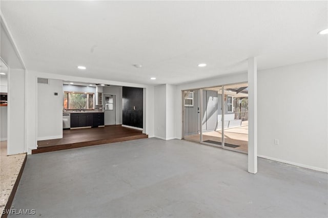 unfurnished living room featuring concrete flooring and sink