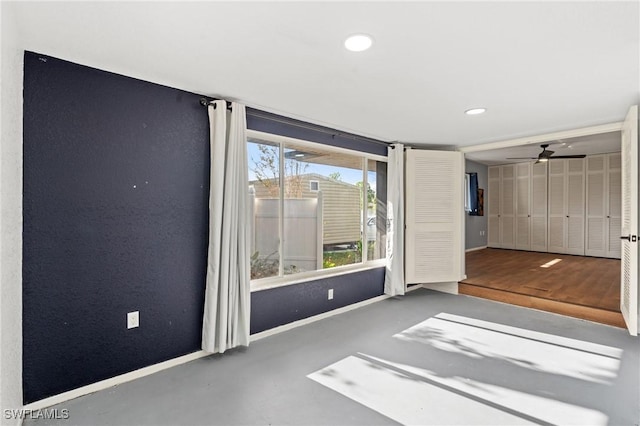 unfurnished room featuring concrete floors and ceiling fan