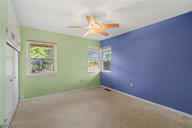 spare room featuring light carpet and ceiling fan