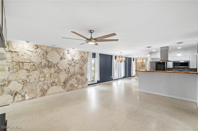 unfurnished living room with ceiling fan with notable chandelier