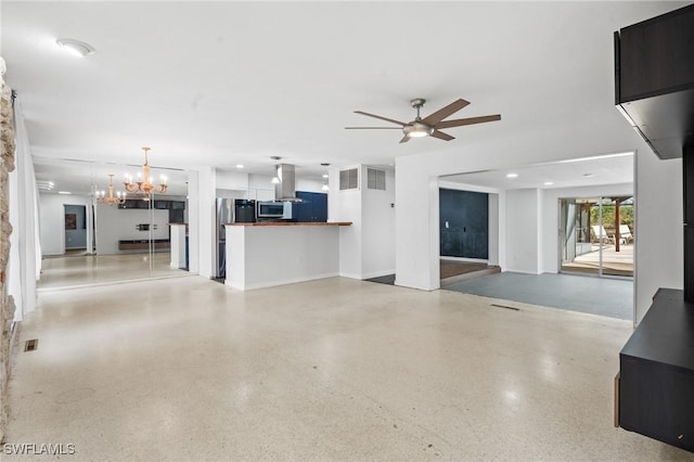 unfurnished living room featuring ceiling fan with notable chandelier