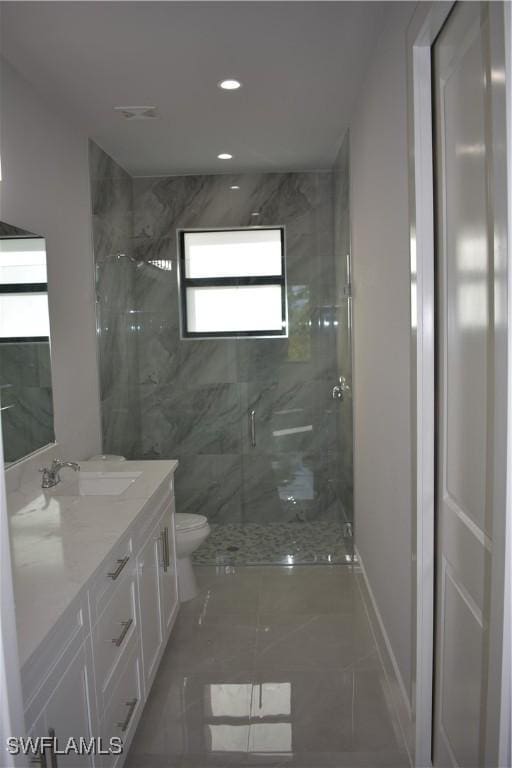 bathroom with vanity, toilet, and a shower with shower door