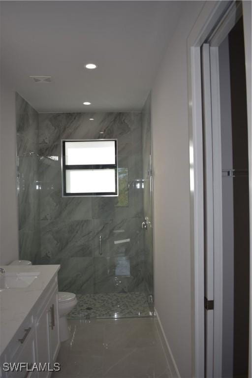 bathroom featuring vanity, toilet, and a shower with shower door