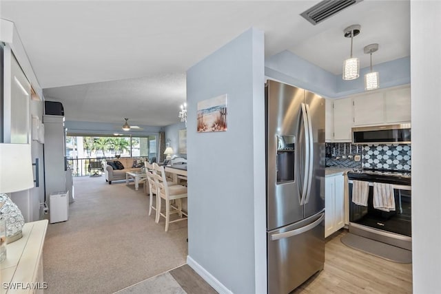 kitchen with white cabinets, ceiling fan, decorative backsplash, hanging light fixtures, and appliances with stainless steel finishes