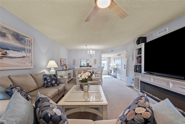 living room featuring ceiling fan with notable chandelier, a textured ceiling, and light colored carpet