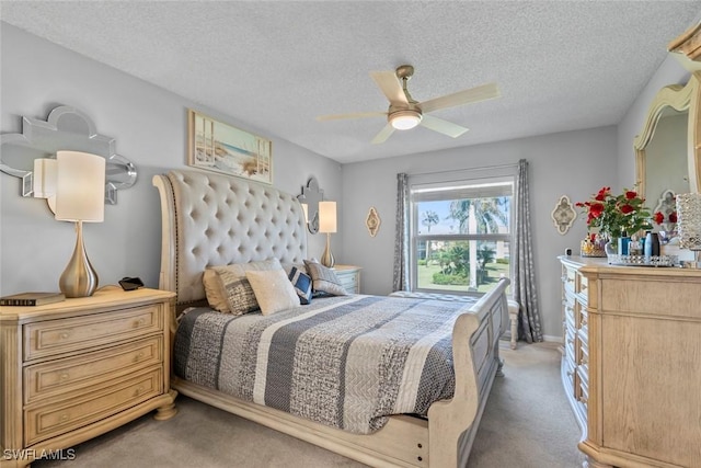 bedroom featuring carpet floors, ceiling fan, and a textured ceiling