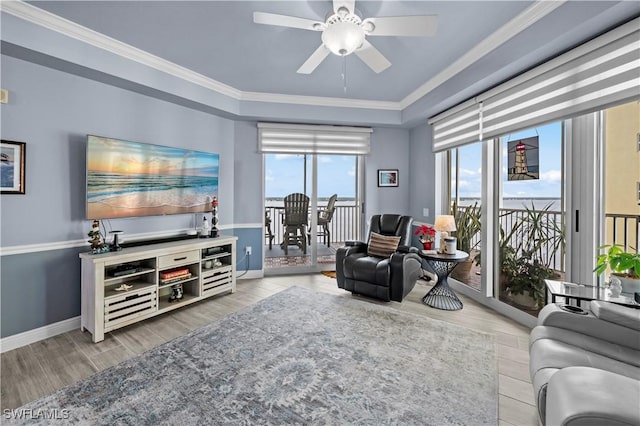 living room with ceiling fan, crown molding, and a tray ceiling