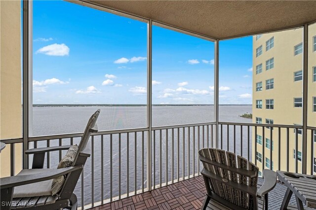 sunroom / solarium featuring a water view