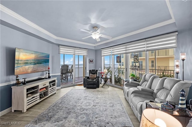 living room with ceiling fan, crown molding, and light wood-type flooring