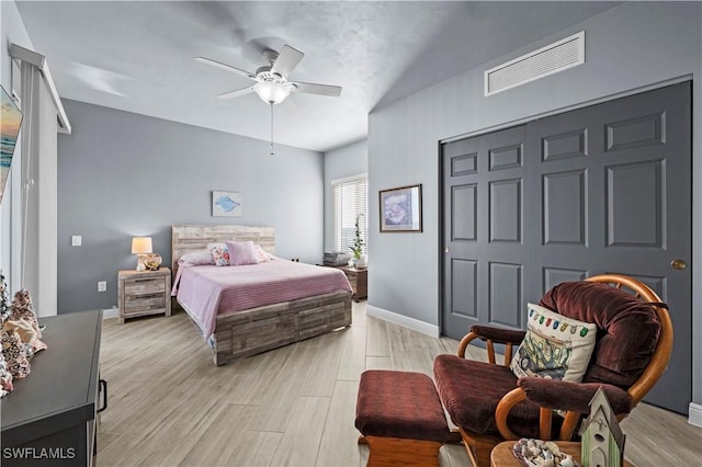 bedroom featuring ceiling fan, light hardwood / wood-style flooring, and a closet