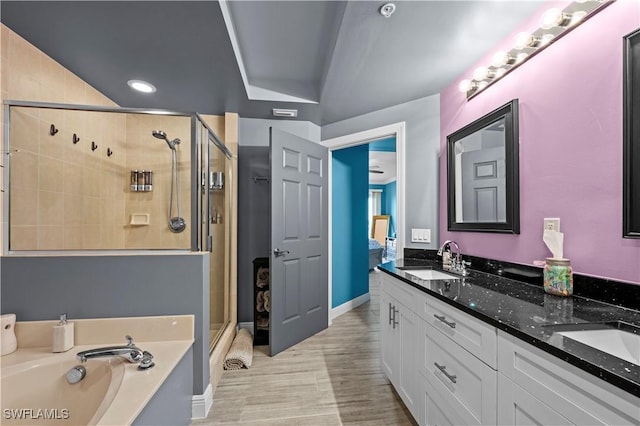 bathroom featuring vanity, independent shower and bath, and lofted ceiling