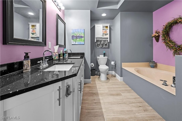 bathroom with a bathing tub, vanity, and toilet