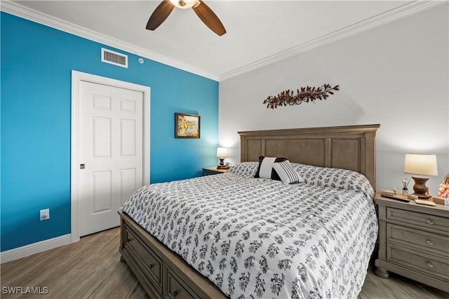 bedroom featuring ceiling fan, light hardwood / wood-style flooring, and ornamental molding