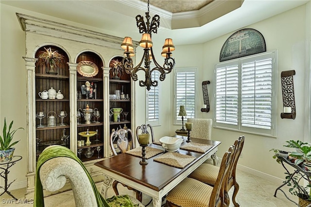 dining room featuring light tile patterned flooring, plenty of natural light, an inviting chandelier, and a tray ceiling