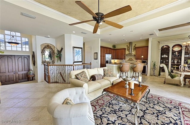 living room featuring light tile patterned floors, crown molding, sink, an inviting chandelier, and a raised ceiling