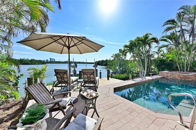 view of pool with an in ground hot tub and a water view