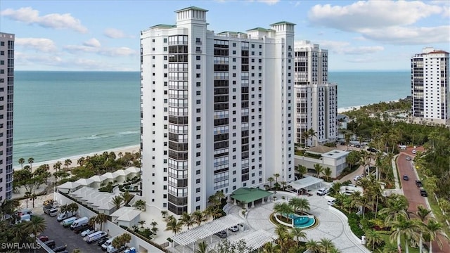 view of building exterior featuring a beach view and a water view