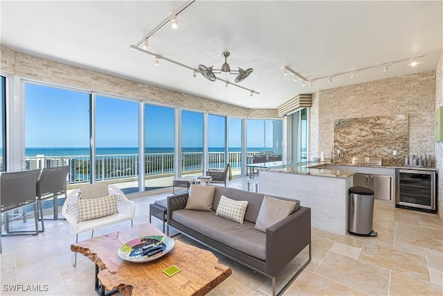 interior space featuring wine cooler, a water view, and a wealth of natural light