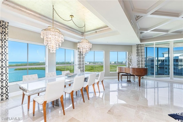 dining area with plenty of natural light, ornamental molding, a chandelier, and a water view